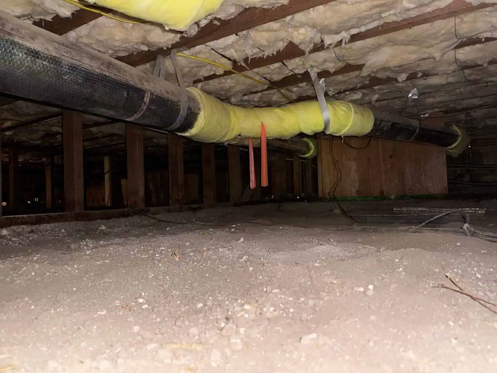 Attic insulation pipes and ductwork in a home attic space.