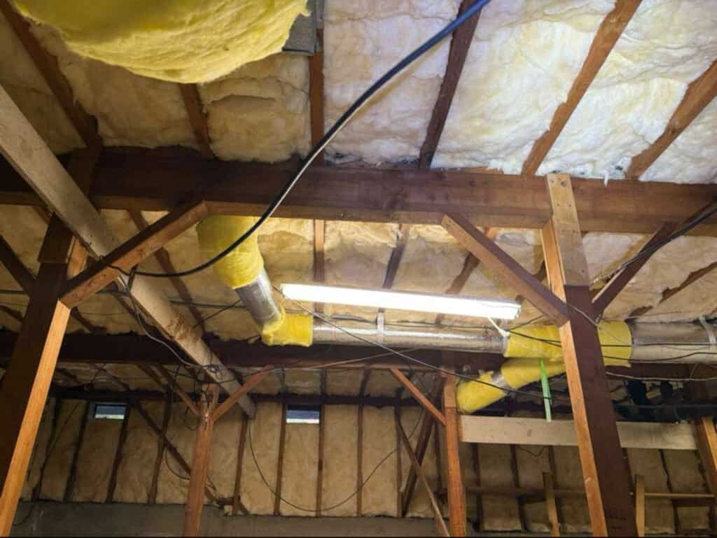 Attic insulation being installed in a home attic for energy efficiency.